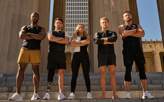 Diverse group of athletes wearing Aion weighted vests standing on stone steps with arms crossed