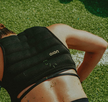 Athletic woman face down doing a push up wearing the Aion women's cropped weighted vest