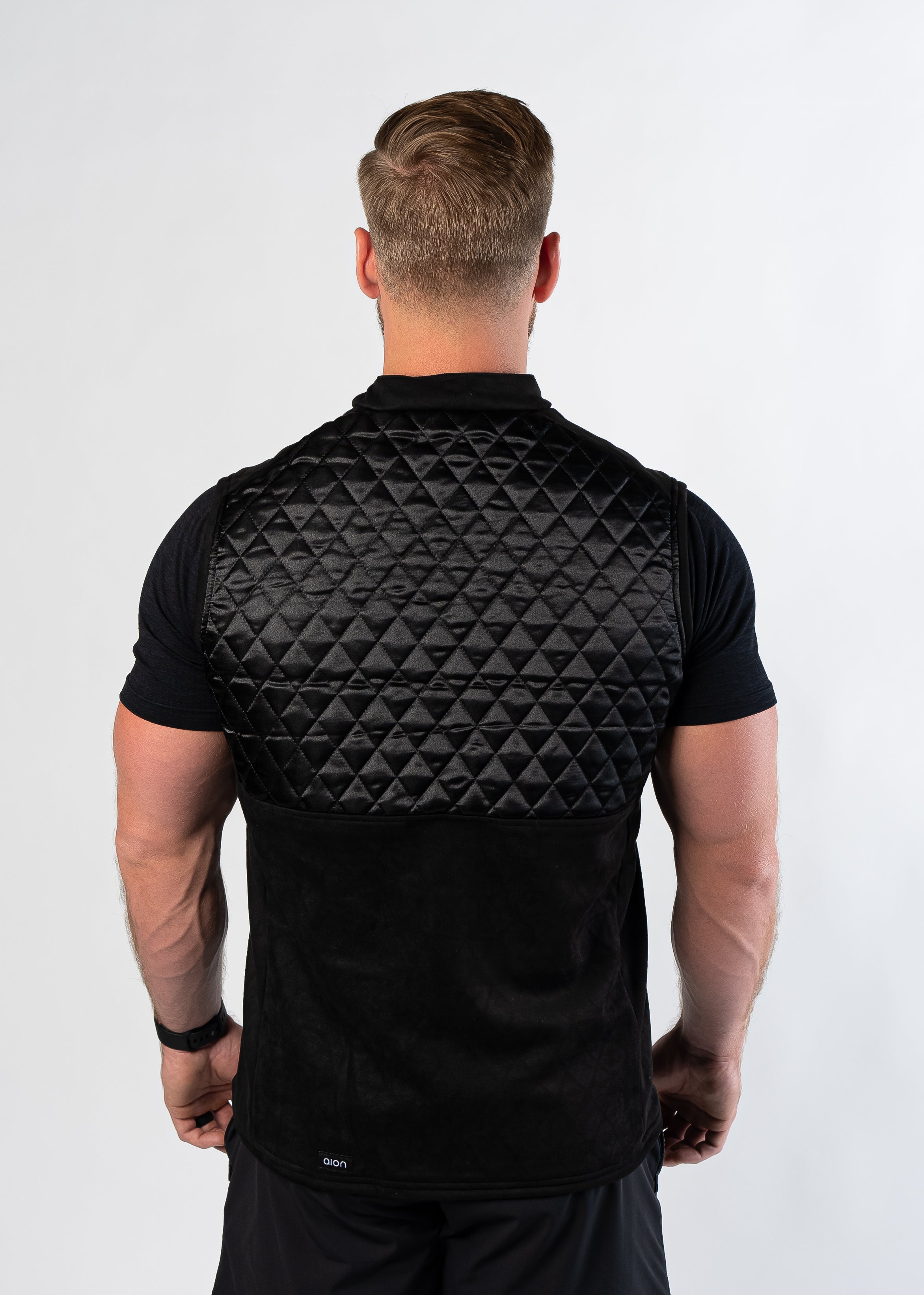 Back view of man wearing Aion Boardroom Recovery Vest in black