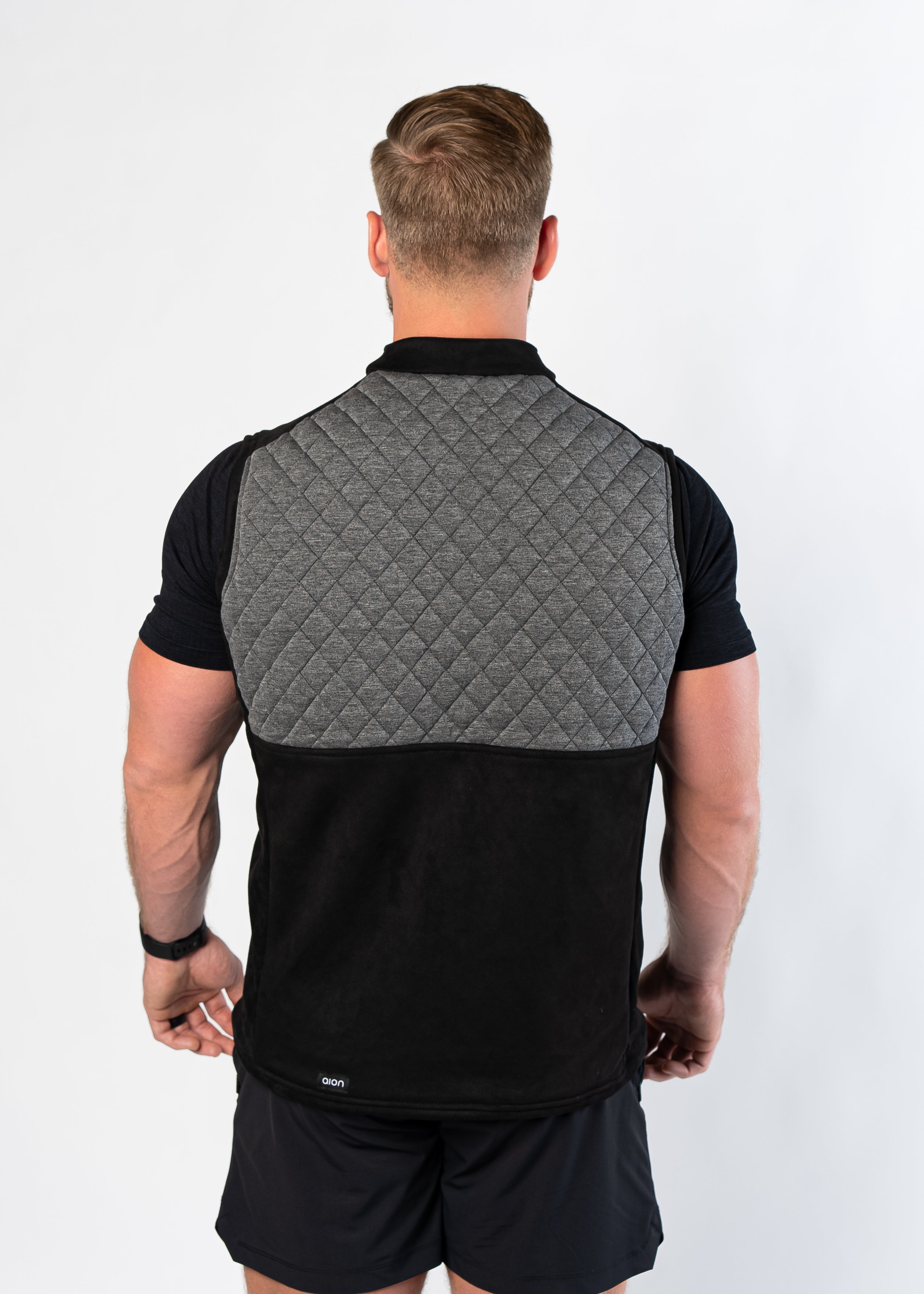 Back view of man wearing Aion Boardroom Recovery Vest in Diamond Gray