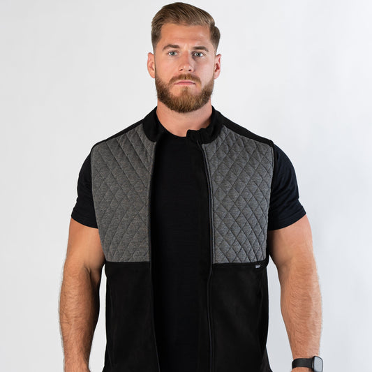 Confident bearded man looking at camera wearing zipped Aion Boardroom Recovery Vest in Diamond Gray