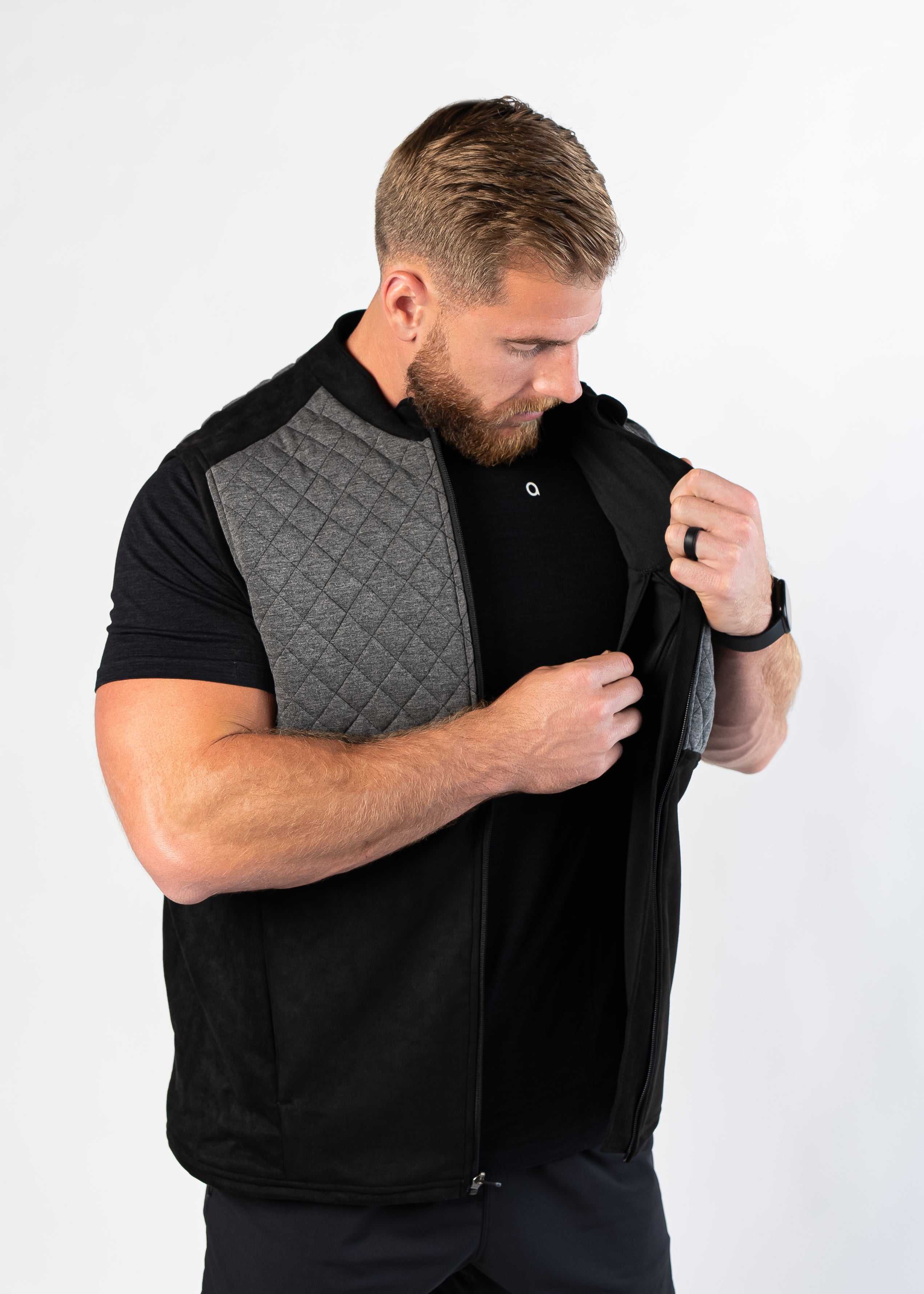 Man examining interior pockets of Aion Boardroom Recovery Vest in Diamond Gray