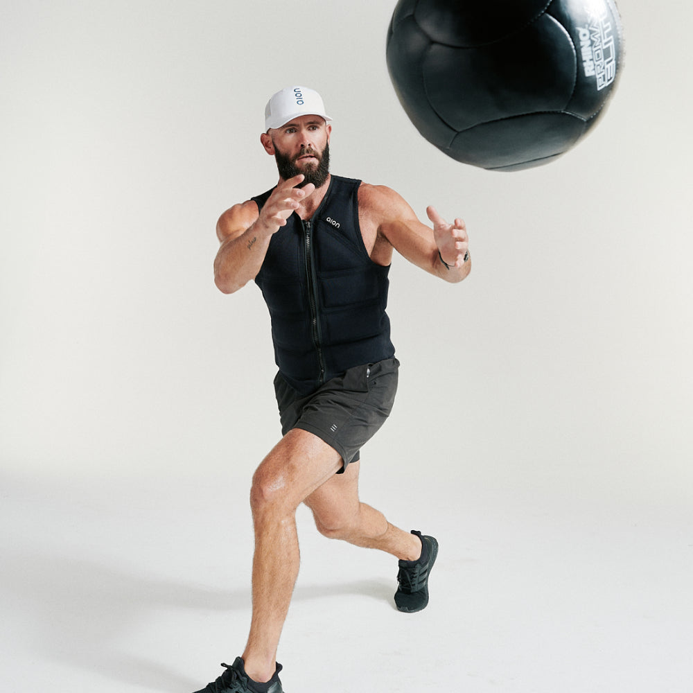 Man playing with a ball wearing Aion resistance weighted workout vest | Model: Height: 6'2" Wearing: Size XL