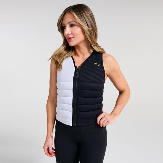 Woman standing firmly in black and white Aion women’s weighted workout vest | Model: Height: 5'5" Wearing: Size S