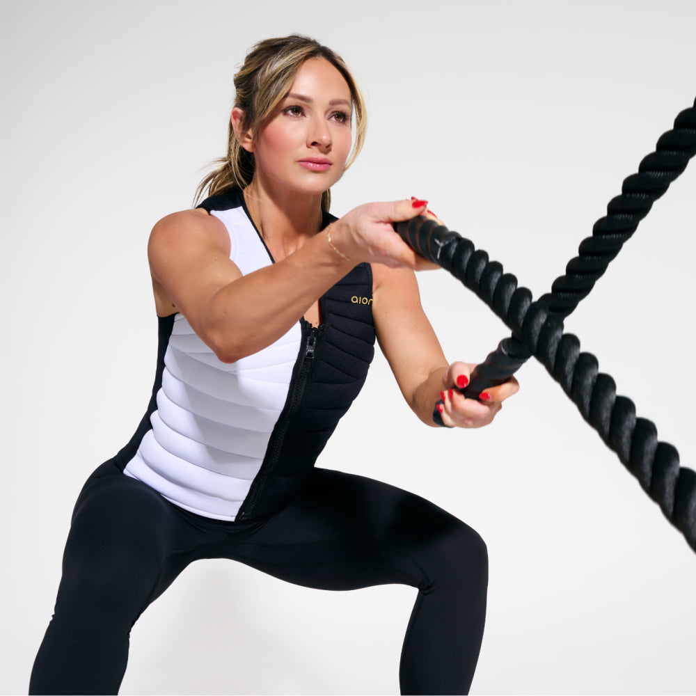 Woman working out in black and white Aion women’s weighted workout vest | Model: Height: 5'5" Wearing: Size S