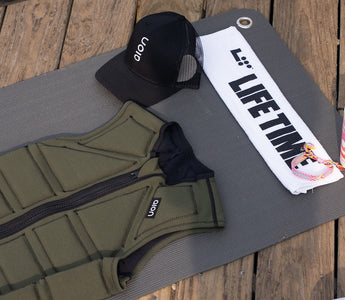 Aion men's weighted vest on a Life Time fitness mat with a Life Time towel and an Aion hat at Life Time MB360 class