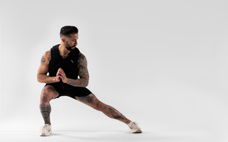 Athlete performing a lateral squat in a weighted vest during calisthenics training, showcasing functional fitness, bodyweight strength, mobility, endurance, and resistance-based performance workouts.
