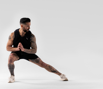 Athlete performing a lateral squat in a weighted vest during calisthenics training, showcasing functional fitness, bodyweight strength, mobility, endurance, and resistance-based performance workouts.
