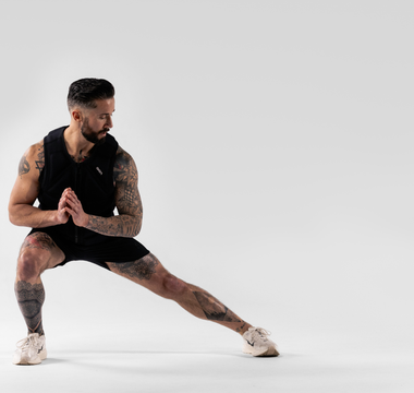 Athlete performing a lateral squat in a weighted vest during calisthenics training, showcasing functional fitness, bodyweight strength, mobility, endurance, and resistance-based performance workouts.