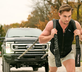 Man pulling a car wearing Aion men's workout vest for heat training