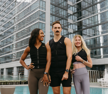 Three individuals wearing Aion weighted vests pose poolside in an urban setting, showcasing functional fitness, strength training, and active lifestyle performance.