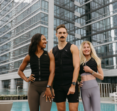 Three individuals wearing Aion weighted vests pose poolside in an urban setting, showcasing functional fitness, strength training, and active lifestyle performance.