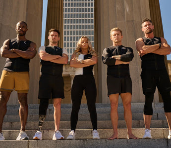 Diverse group of athletes wearing Aion weighted vests standing on stone steps with arms crossed