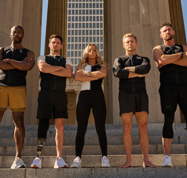 Diverse group of athletes wearing Aion weighted vests standing on stone steps with arms crossed