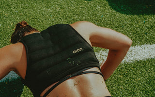 Athletic woman face down doing a push up wearing the Aion women's cropped weighted vest