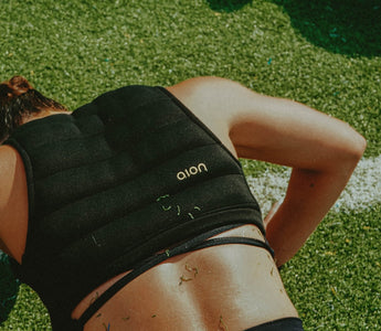 Athletic woman face down doing a push up wearing the Aion women's cropped weighted vest