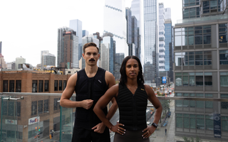 Two athletes wearing Aion weighted vests stand confidently on a city rooftop, showcasing strength, performance, and urban training against a modern skyline backdrop