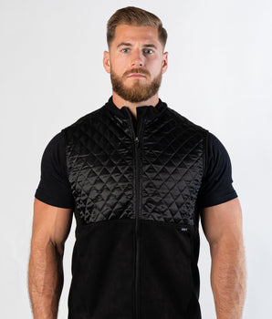 Confident bearded man looking at camera wearing zipped Aion Boardroom Recovery Vest in black