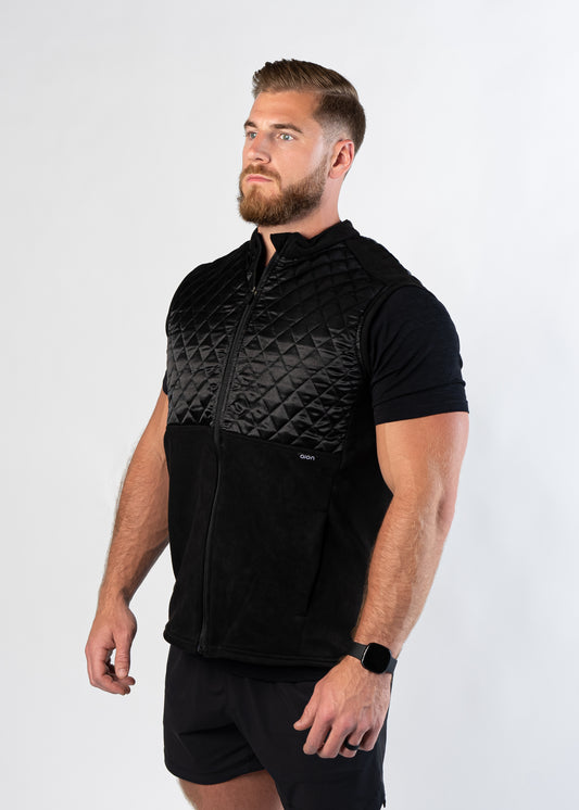 Athletic man in gym shorts showing side view of Aion Boardroom Recovery Vest in black