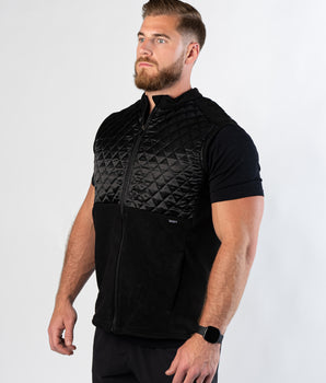 Athletic man in gym shorts showing side view of Aion Boardroom Recovery Vest in black
