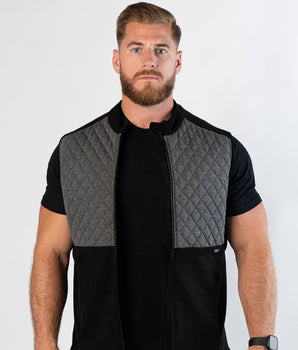 Confident bearded man looking at camera wearing zipped Aion Boardroom Recovery Vest in Diamond Gray