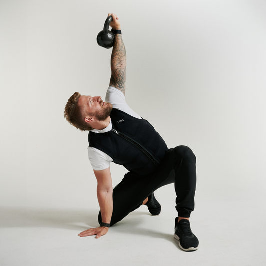 Man lifting dumbbells while wearing Aion men’s weighted workout vest | Model: Height: 5'11" Wearing: Size L